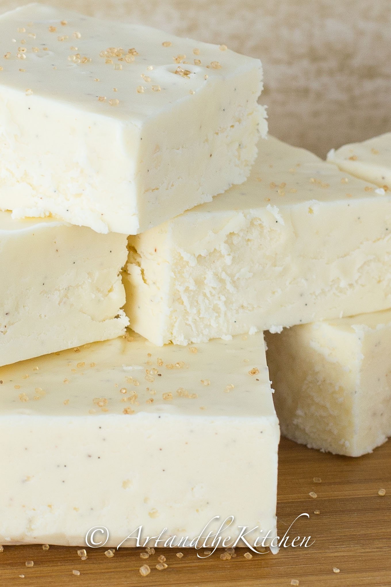 Stack of squares of white fudge made with eggnog flavor.