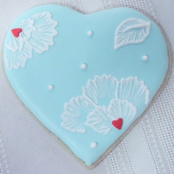 Heart shaped cookie decorated with blue icing.