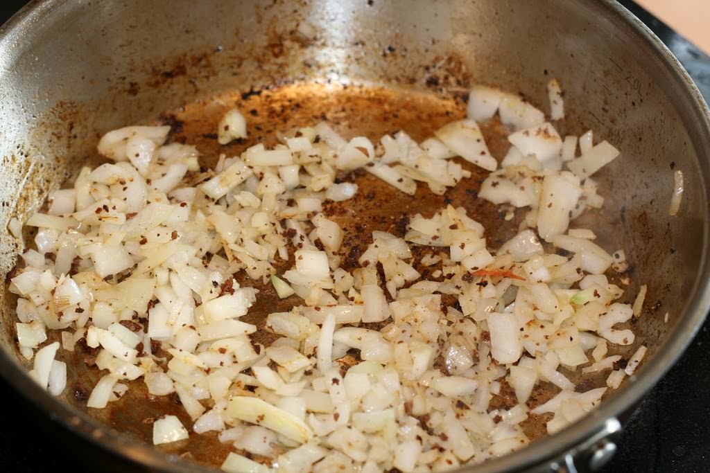 Onions cooking in frying pan.