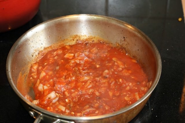 Frying pan filled with tomato sauce.