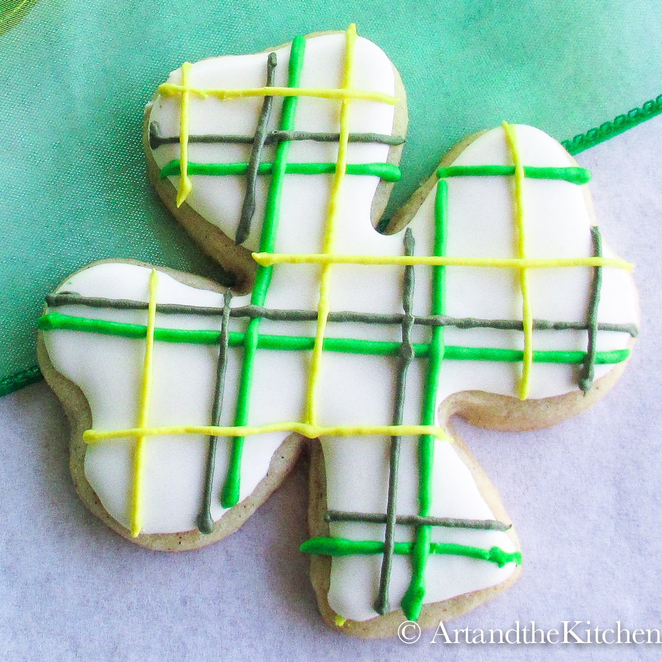 Royal icing decorated Shamrock shaped cookie tartan pattern.