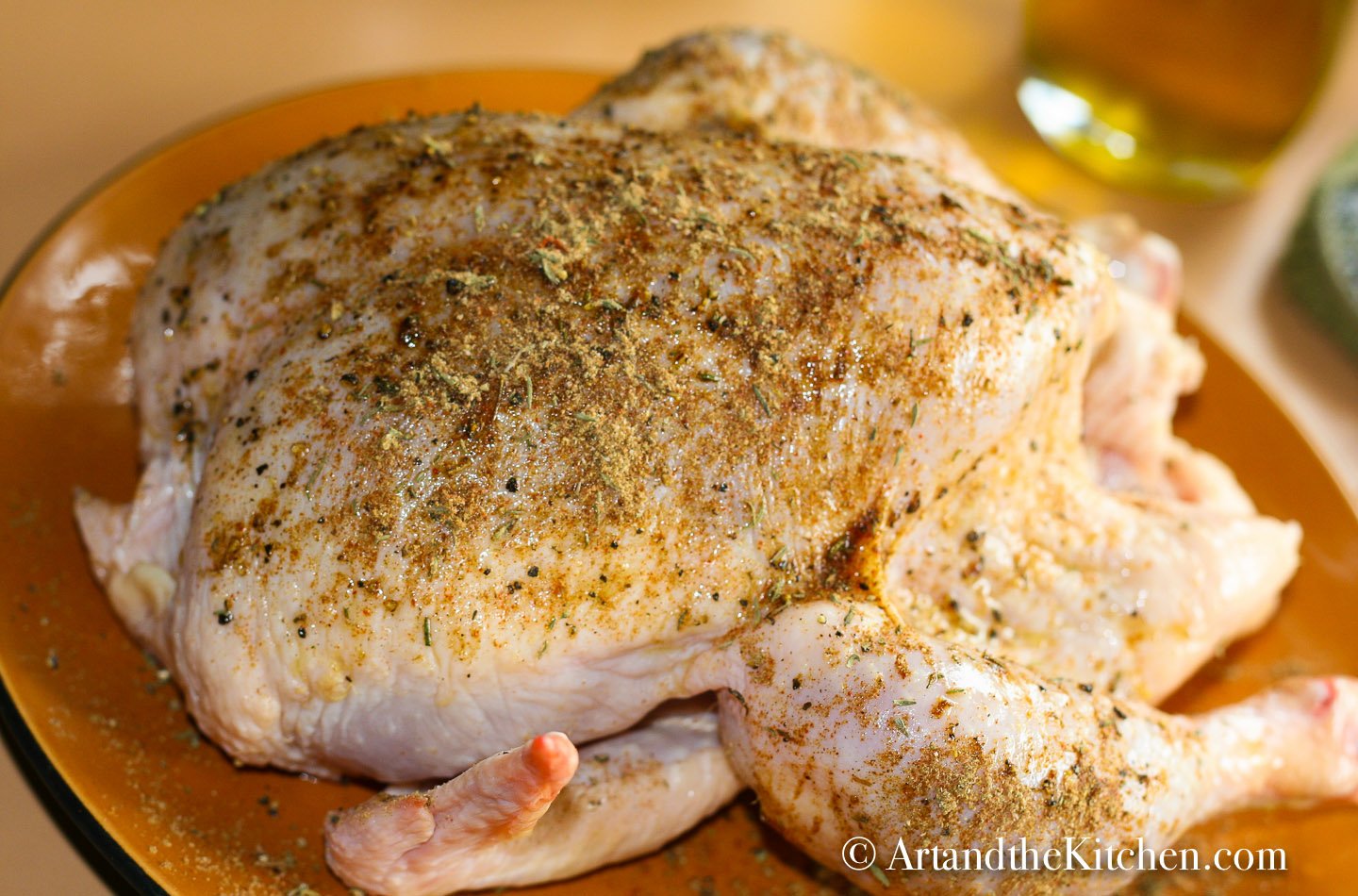 Whole raw chicken coated in spices.