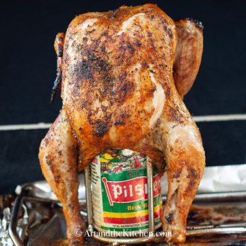 Whole roasted chicken on beer can roasting stand.