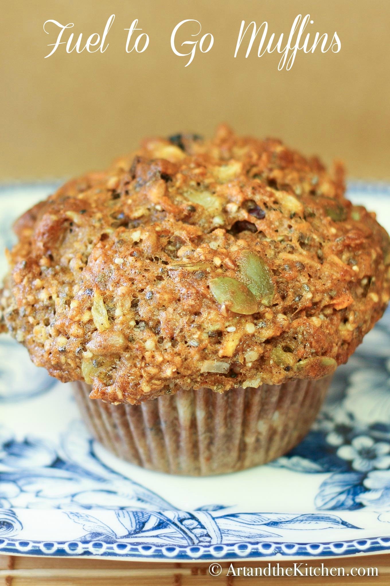 Healthy muffin with whole grains, dried fruit, pumpkin and sunflowers on blue plate.
