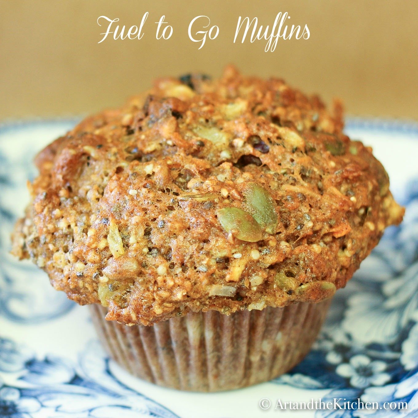 Muffin with pumpkin seeds, sunflower seed and whole grain on decorative blue plate.