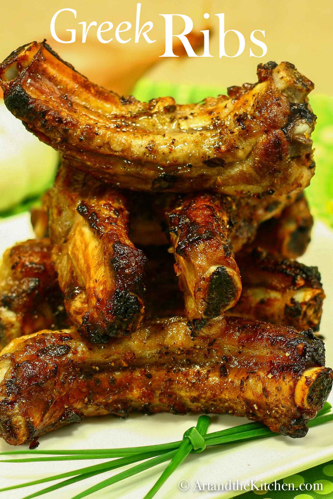 Stack of baked baby back rib pieces with garnished green onion sprig.