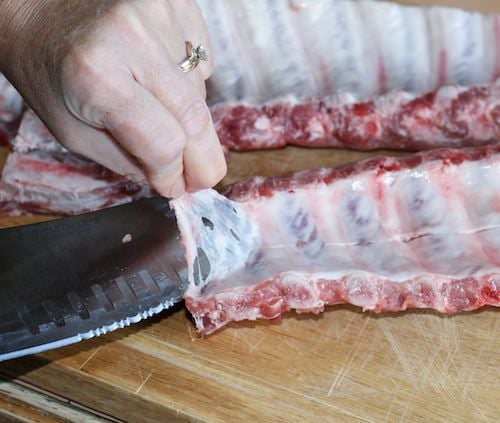 Removing skin membrane from pork ribs.