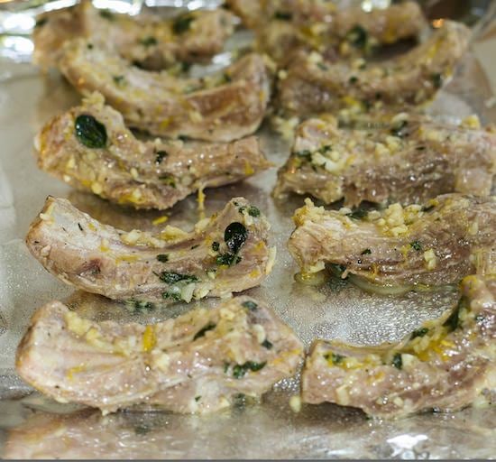 Marinated baby back ribs on foil lined baking sheet.