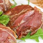 Beef burgers covered with a layer of prosciutto.