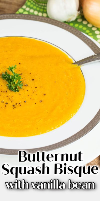 White bowl of squash soup garnish with cracked pepper and parsley.