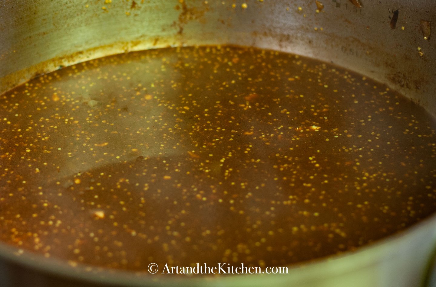 Skillet filled with beef broth, red wine and spices.