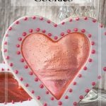 Two heart shaped cookies with a red stained glass looking center.