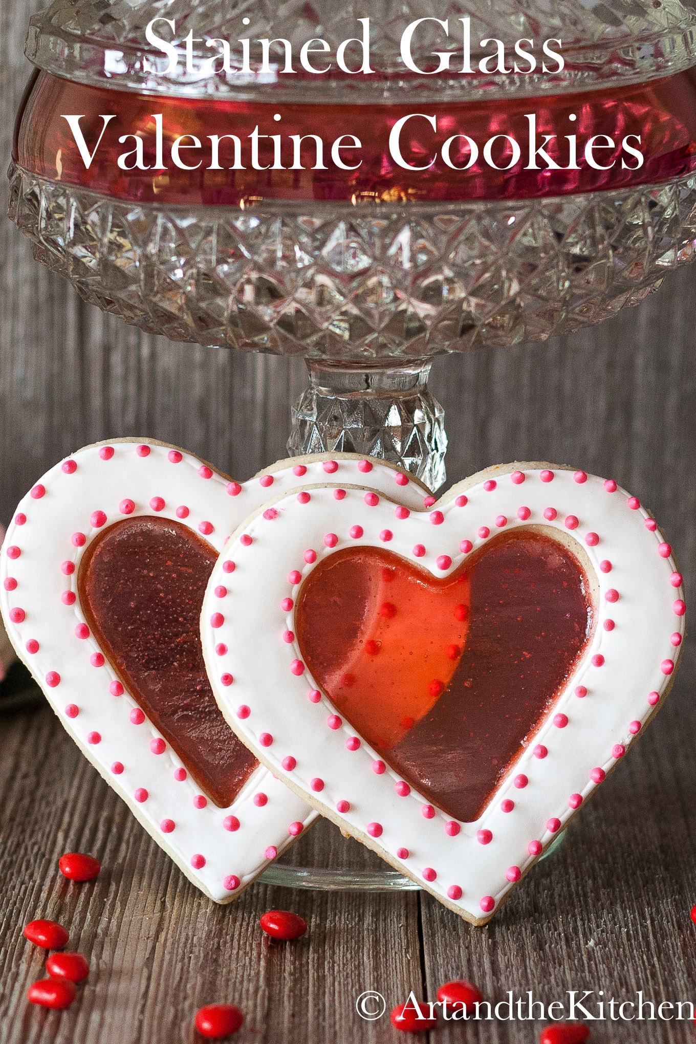 Two heart shaped cookies with a red stained glass looking center.