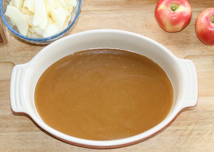 Layer of caramel sauce in oval baking dish.