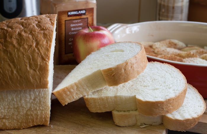 Loaf of white bread with three slices cut.