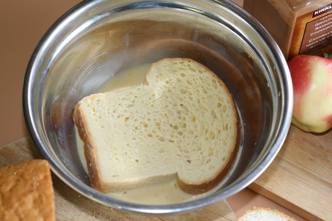 Slice of bread soaking in a milk and egg mixture.