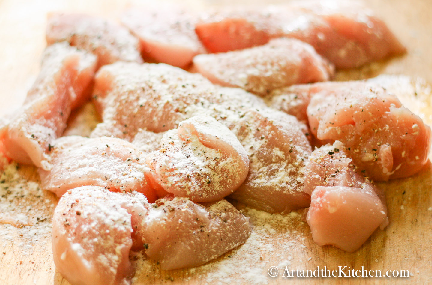 chicken breasts chopped into bite sized pieces sprinkled with flour.