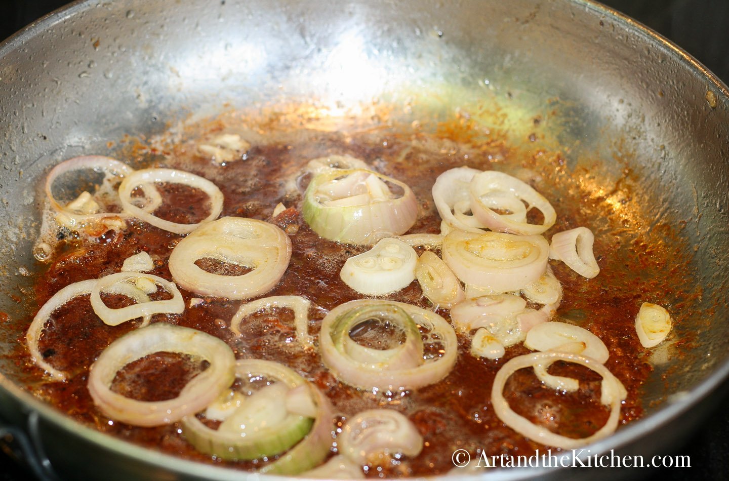 sliced shallots sautéing in skillet with browned bits from searing chicken.