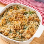 Square baking dish filled with green bean casserole topped with crunchy shallots.