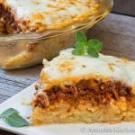 Slice of pie with layers of spaghetti, meat sauce and cheese.
