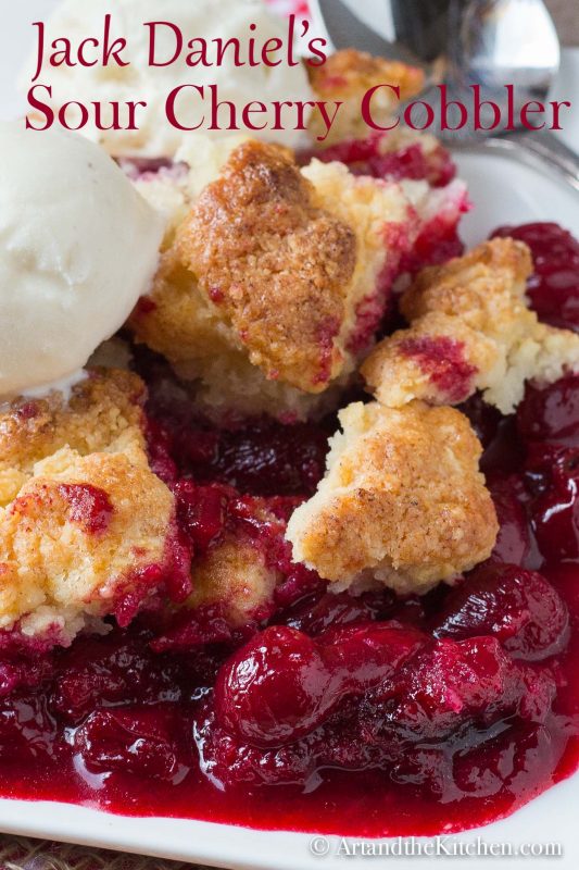 Plate of cherry cobbler topped with a scoop of ice cream.