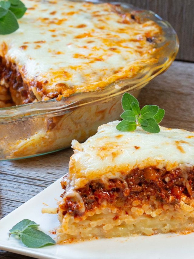 Slice of spaghetti pie on plate with whole pie in background.