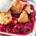 Cherry filling topped with cobbler biscuit crust and a scoop of vanilla ice cream.