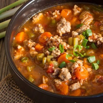 Soup with chunks of ground turkey, vegetables simmered in a tomato beef broth served in a black bowl
