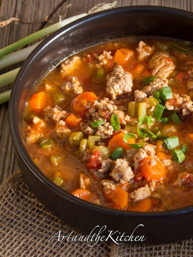 Soup with chunks of ground turkey, vegetables simmered in a tomato beef broth served in a black bowl