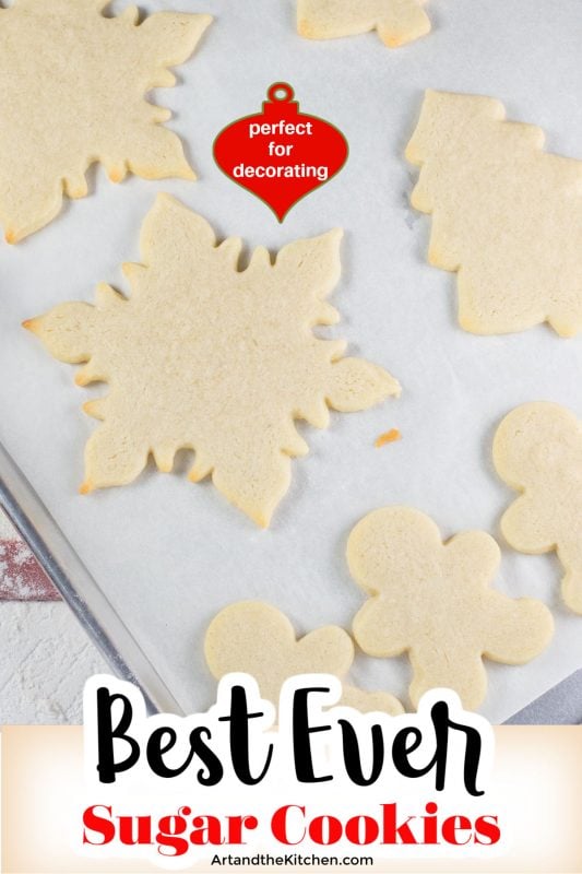 White parchment line baking pan filled with holiday shaped baked cookies.