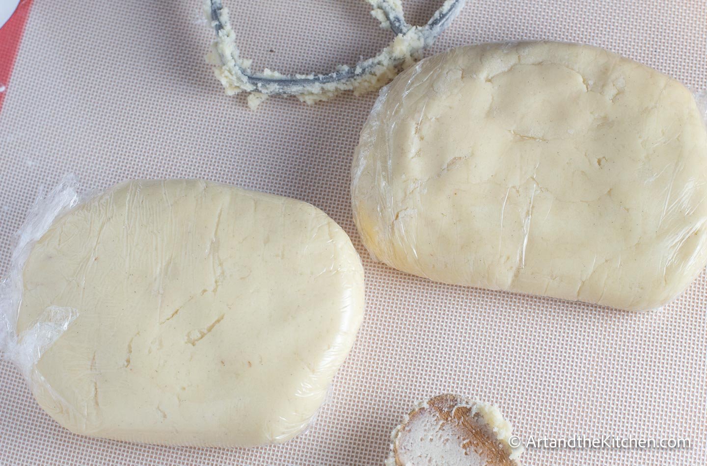 Two disks of cookie dough tightly wrapped in plastic wrap.