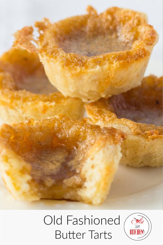 Stack of homemade butter tarts on white plate