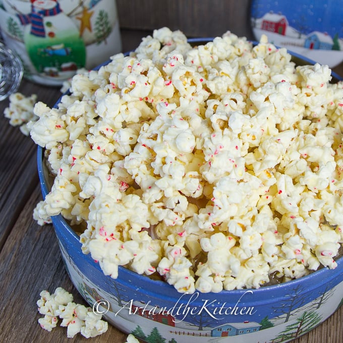 Decorative tin of white chocolate and candy cane popcorn. 