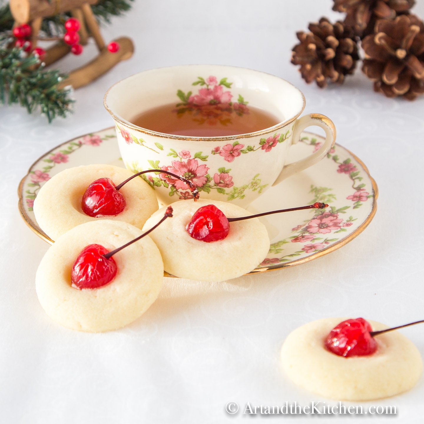 Antique teacup and sauce filled with tea. Short bread cookies on side of plate.