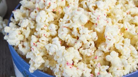 Decorative Holiday container filled with popcorn coated in white chocolate and bits of candy cane.