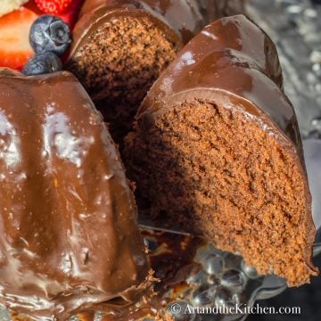 Chocolate cake with slice taken out from cake. Covered in chocolate ganache.