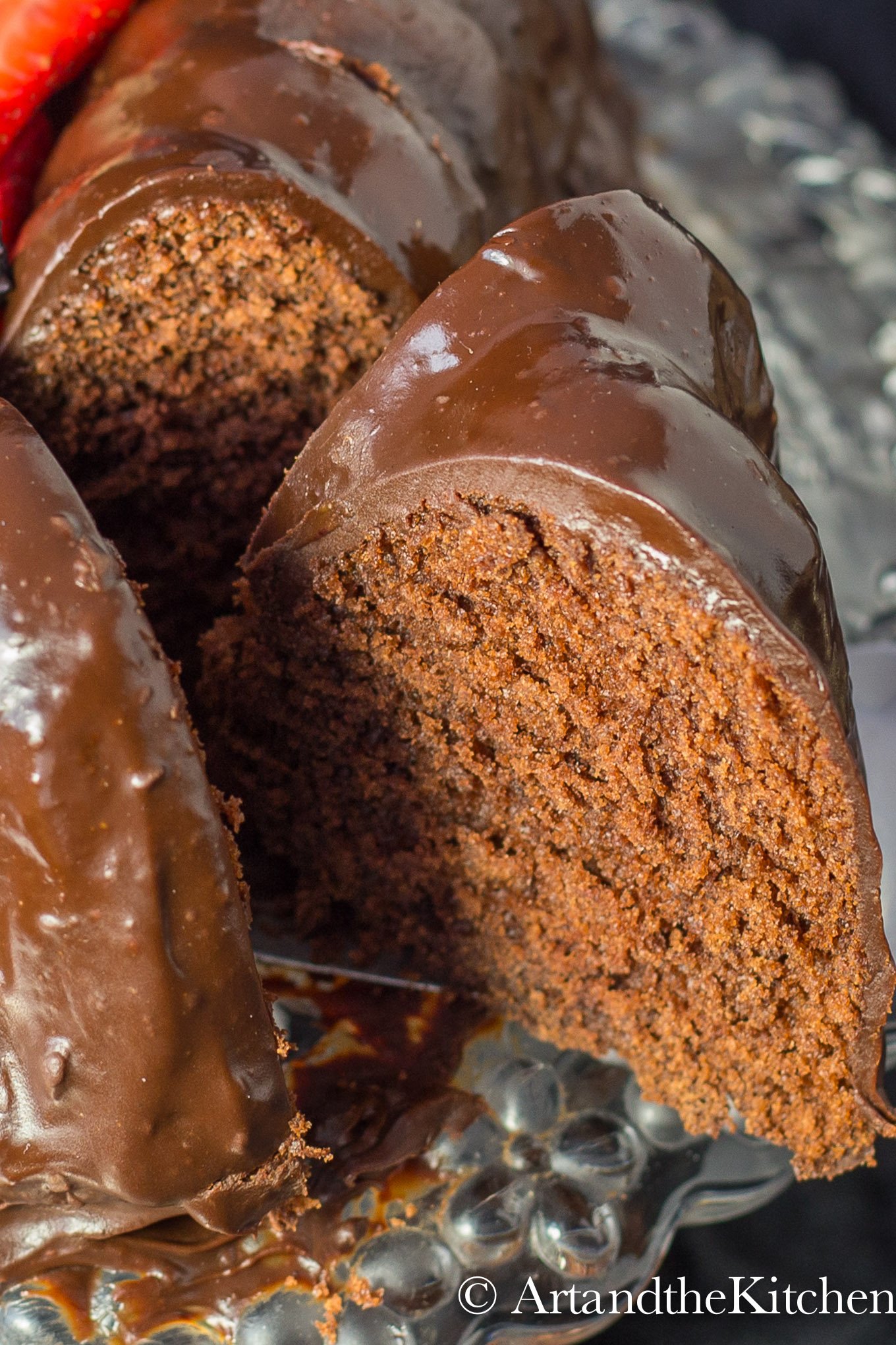 Chocolate cake with slice taken out from cake. Covered in chocolate ganache.