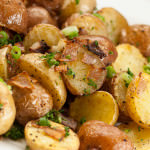 Pile of crispy roasted potatoes with onions.