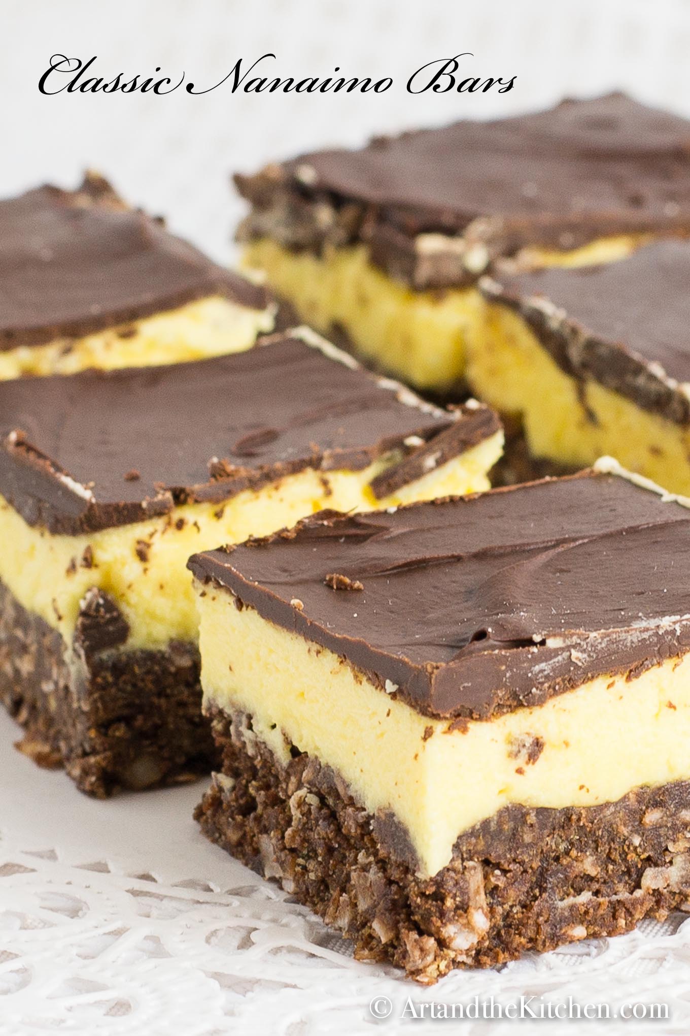 Rows of cut up Nanaimo bars made with layers of chocolate, yellow custard and chocolate coconut