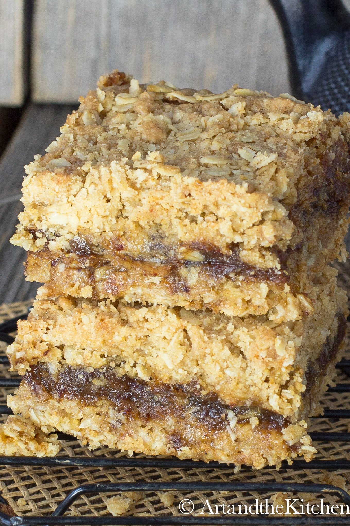 A stack of two date squares on black cooling rack.