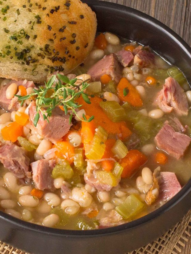 Bowl of ham and bean soup garnish with slice of garlic toast.