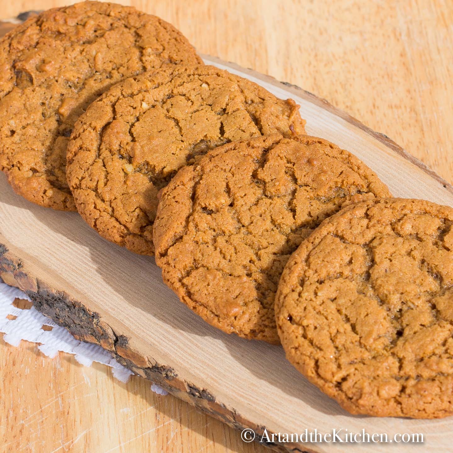 Four molasses cookies on log board.