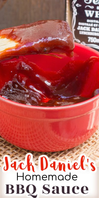 Small red bowl filled with barbecue sauce scooped up with brush from bowl.