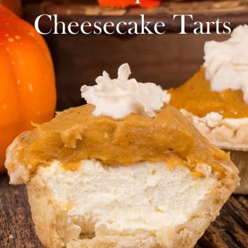 Single tart with layers of cream cheese, pumpkin filling and a dollop of whipped cream.