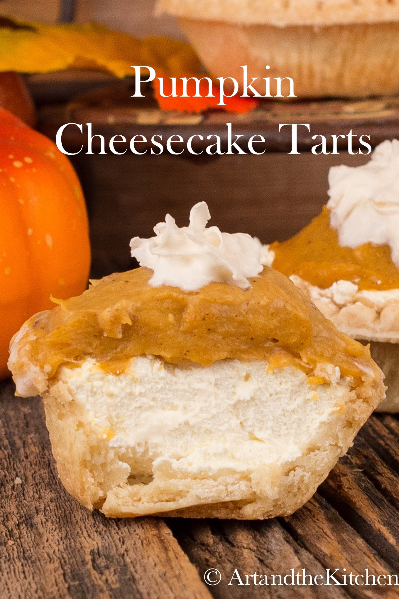 Single tart with layers of cream cheese, pumpkin filling and a dollop of whipped cream.