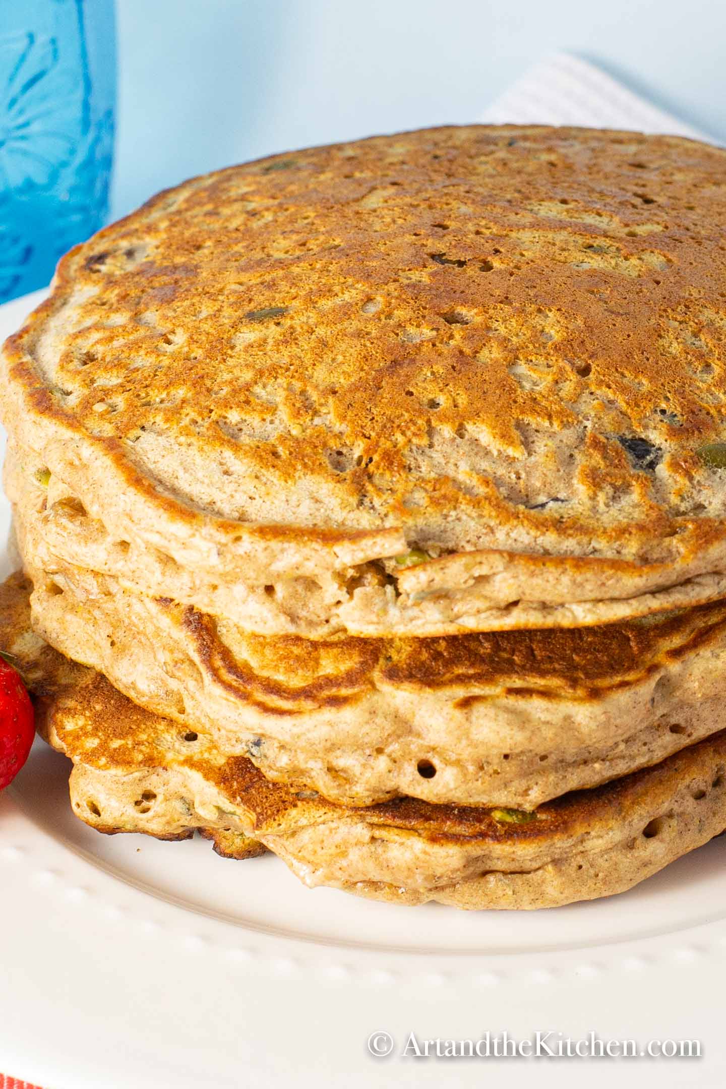 Stack of whole wheat pancakes on white plate