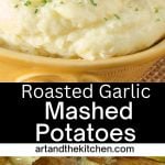 Yellow bowl filled with mashed potatoes, topped with clove of roasted garlic.