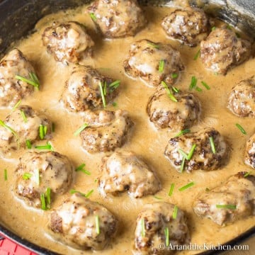 pan seared meatballs with rich creamy sauce in cast iron pan