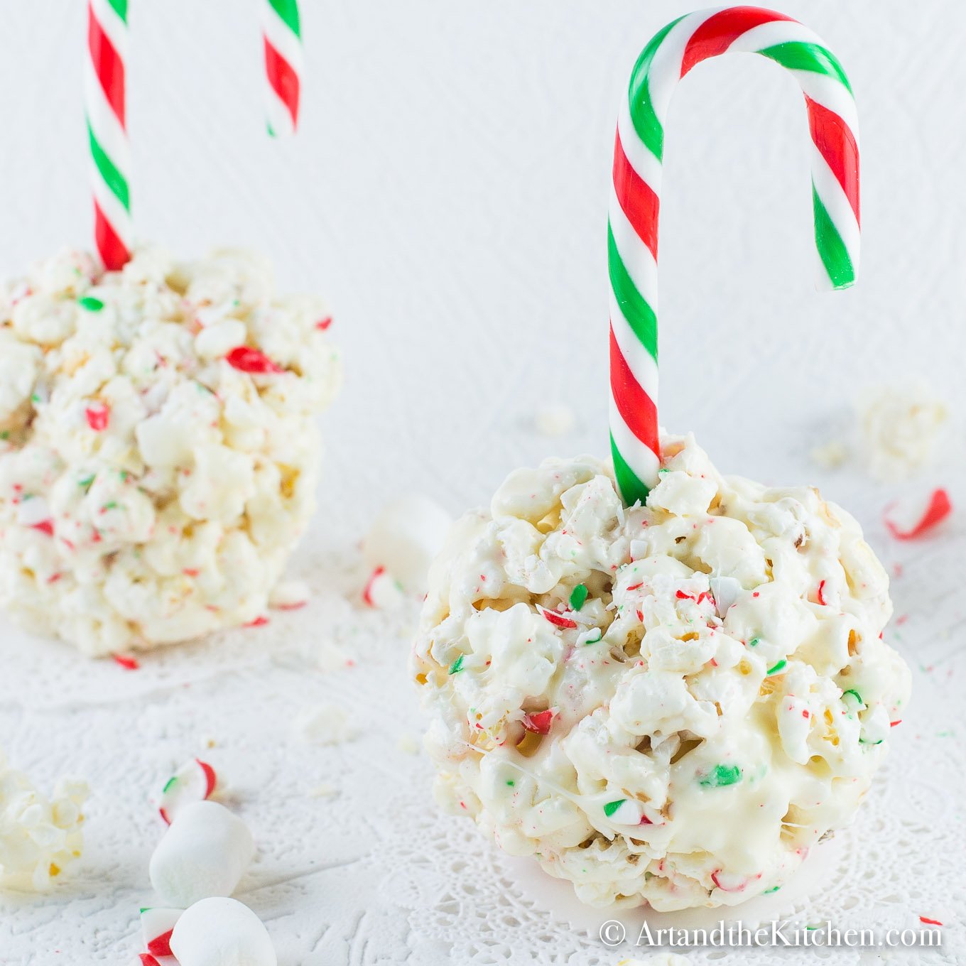 Popcorns ball made with crushed candy canes and a candy cane stick. 