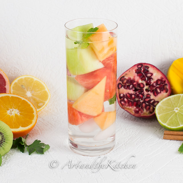 tall glass of water with cantaloupe, honeydew and watermelon chunks.